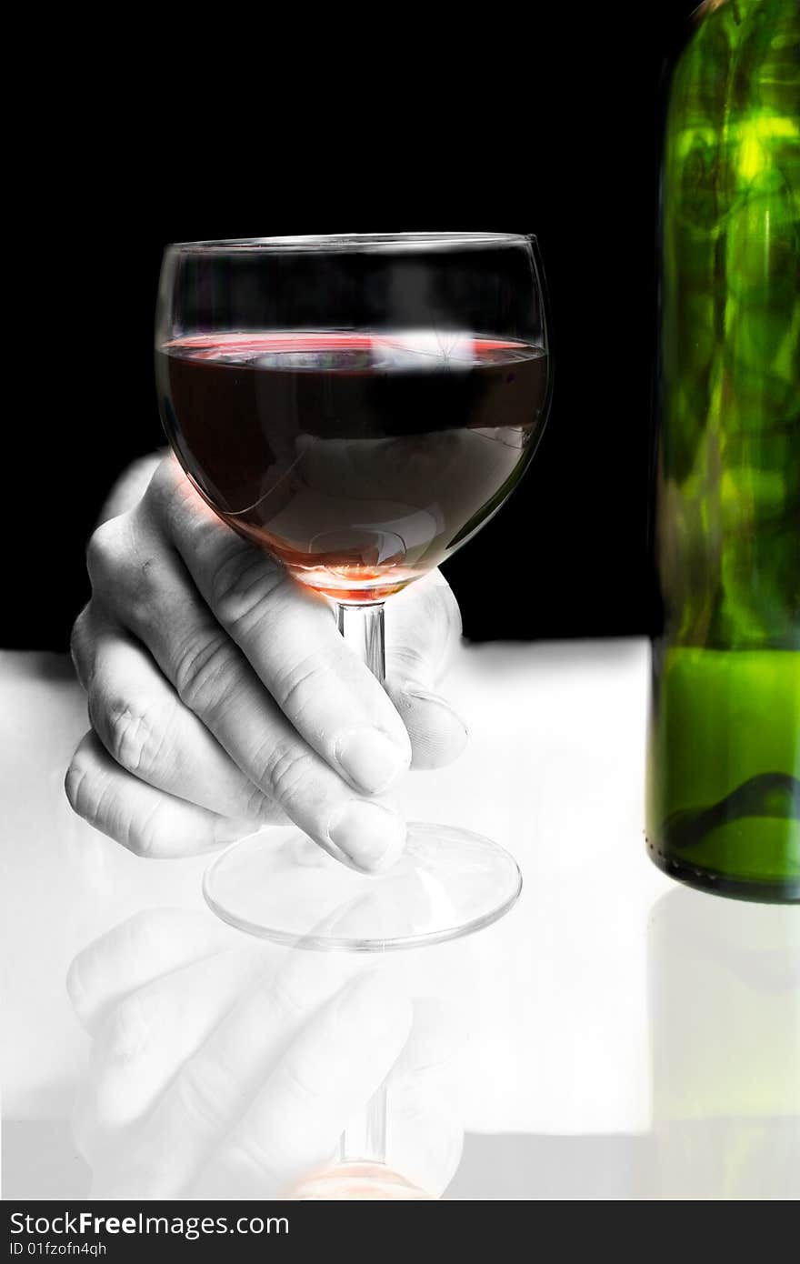 Hand holding red wine glass with bottle. Hand holding red wine glass with bottle