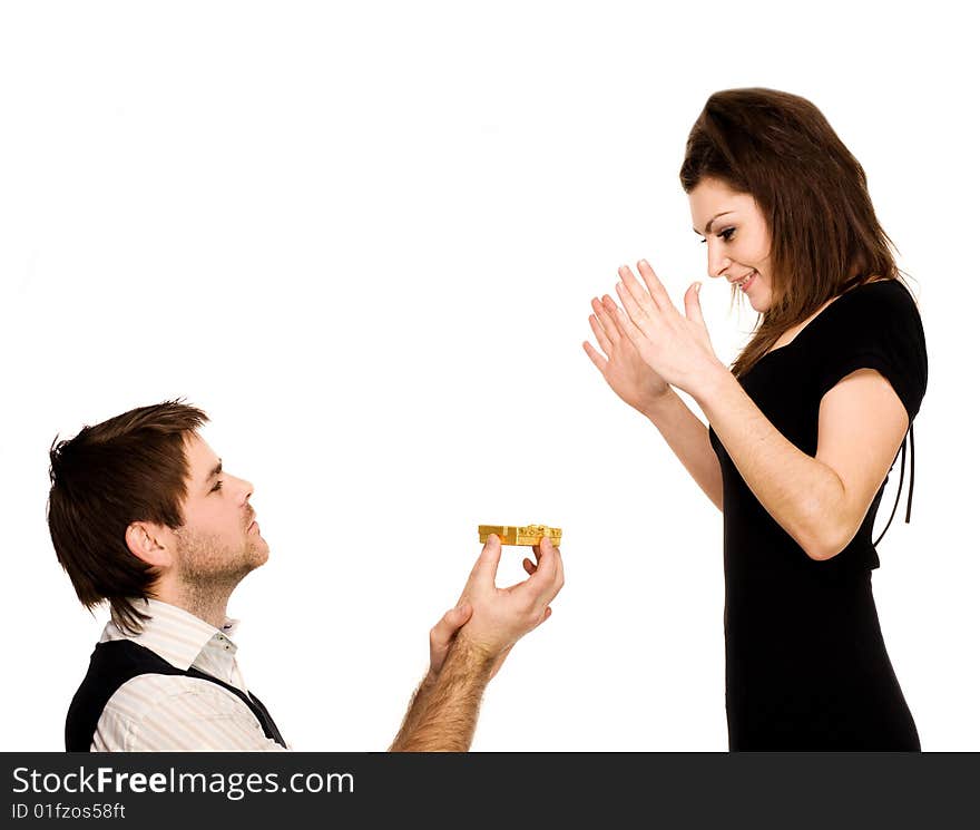 An image of surprised woman and man with present standing on his knee. An image of surprised woman and man with present standing on his knee