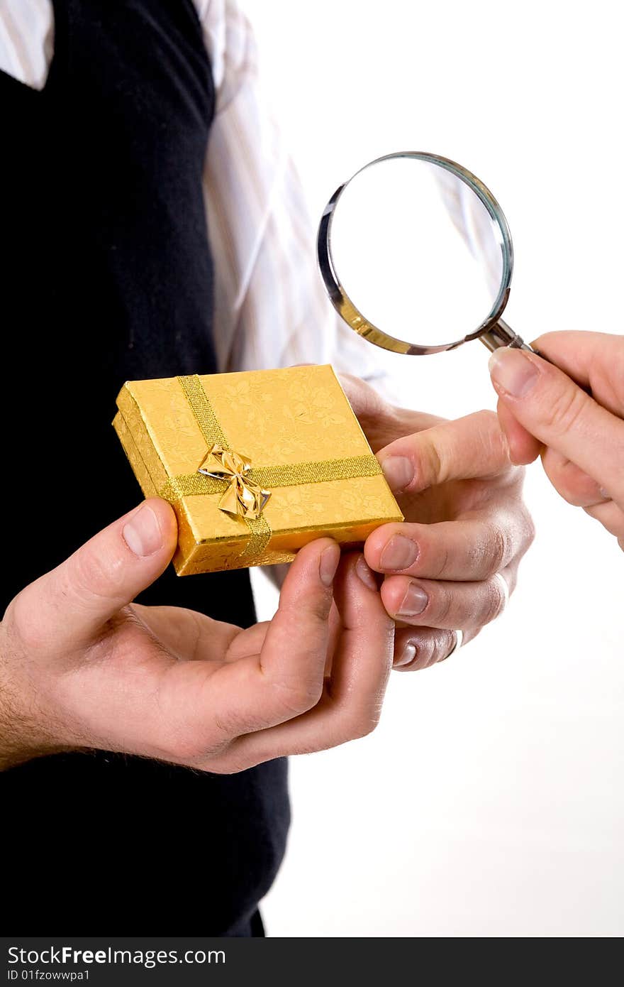 Stock photo: an image of a yellow box in hands of a man and a magnifier. Stock photo: an image of a yellow box in hands of a man and a magnifier