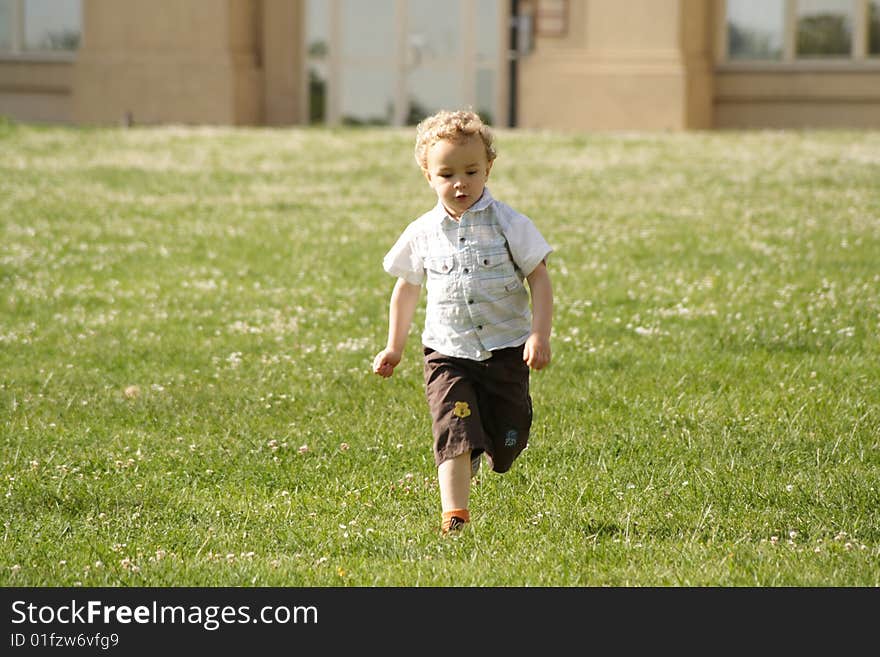 Toddler runing on the grass in urban park. Toddler runing on the grass in urban park