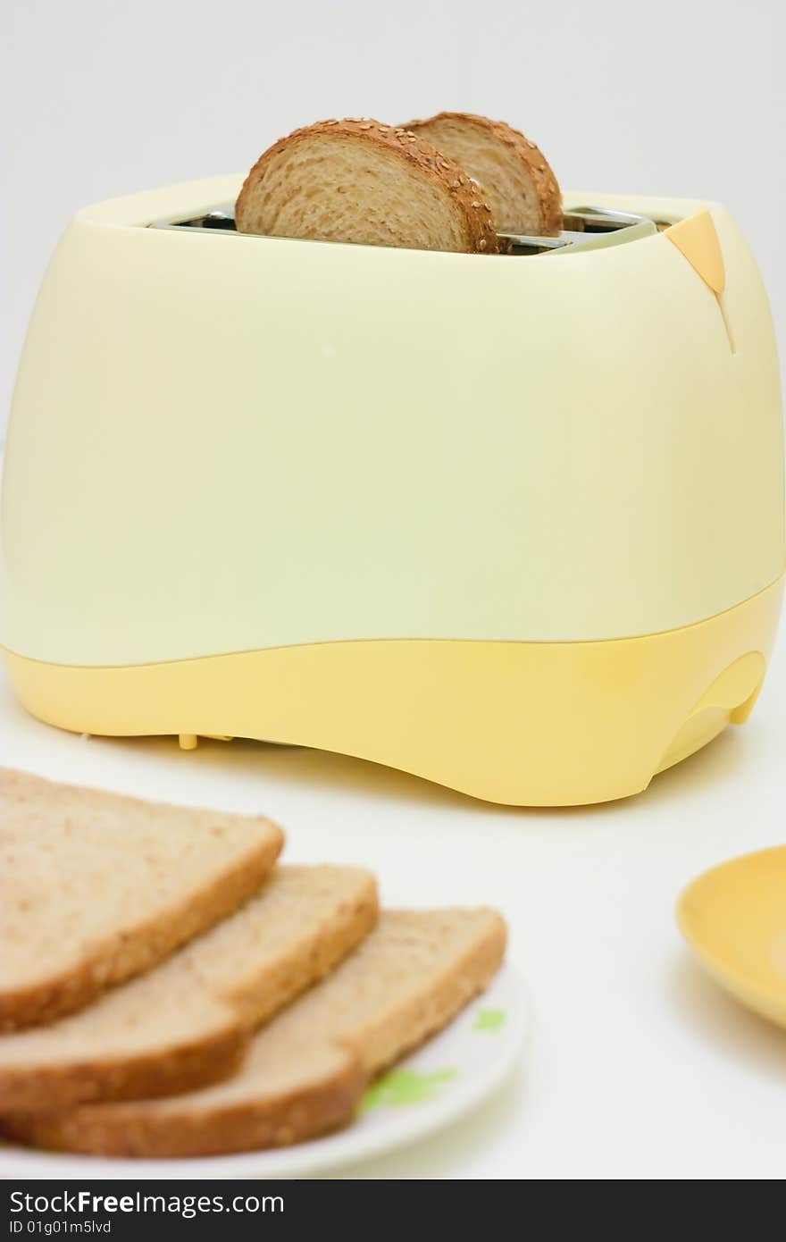 A table setting with breakfast food and toaster. A table setting with breakfast food and toaster