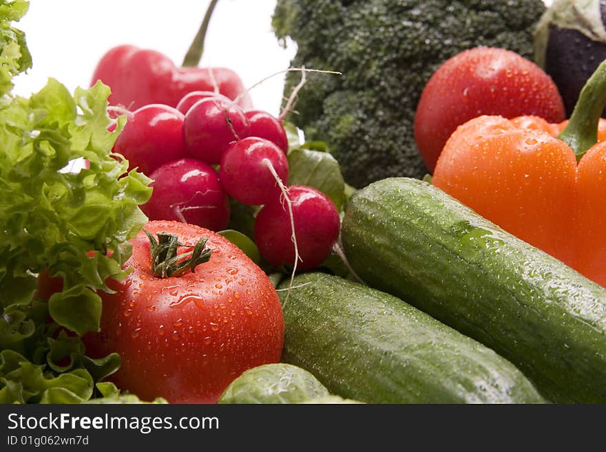 A group of sprinkled fresh vegetables on white background. A group of sprinkled fresh vegetables on white background.