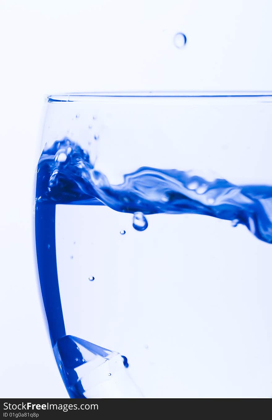 Blue Glass with Splashing water. Coolness Drink