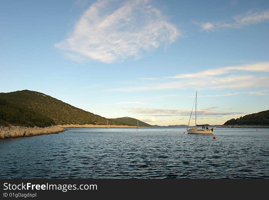 Late afternoon sailing boat mooring in a bay of Croatian Islands. Late afternoon sailing boat mooring in a bay of Croatian Islands