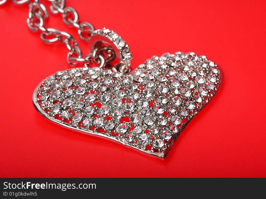 A silver heart on a red background. A silver heart on a red background