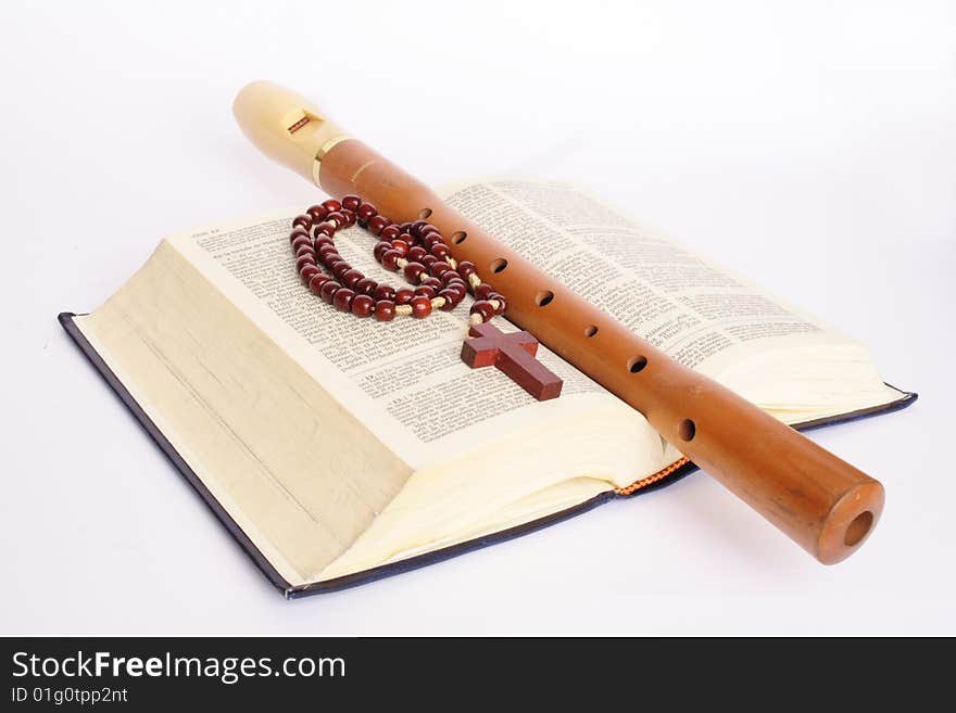 Flute with bible and rosary in white background. Flute with bible and rosary in white background