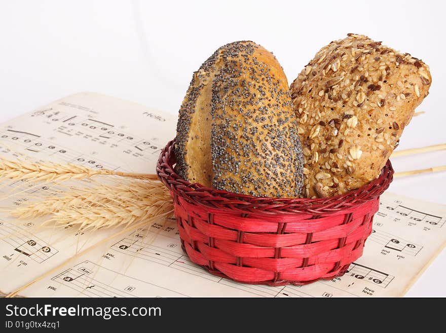 Small red basket with bread and music book. Small red basket with bread and music book