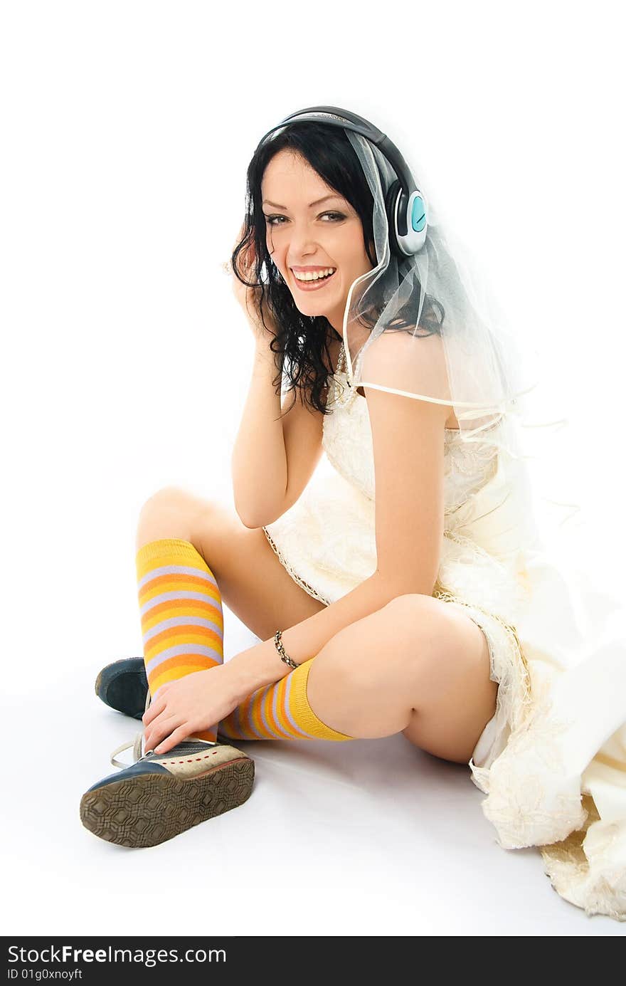 Happy bride wearing earphones and sporting shoes