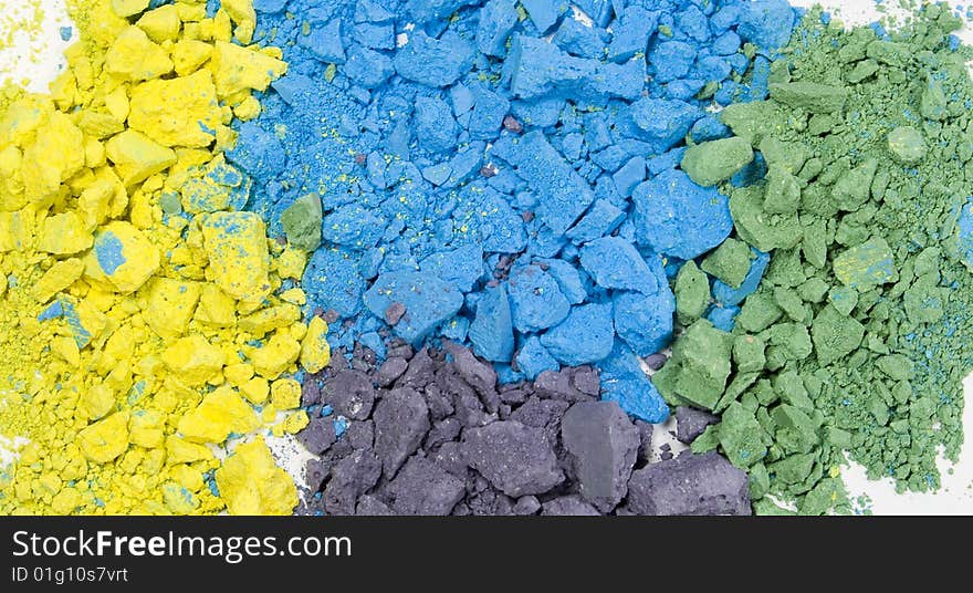 Colored grainy crushed chalk's textured background. Blue, yellow, green and purple