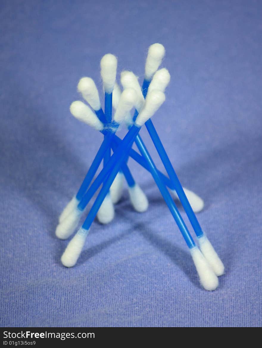 Close up of several cotton ear wipes isolated on blue background