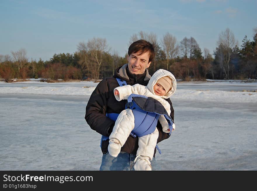 Father and baby in a carrier having a good time on winter weekend