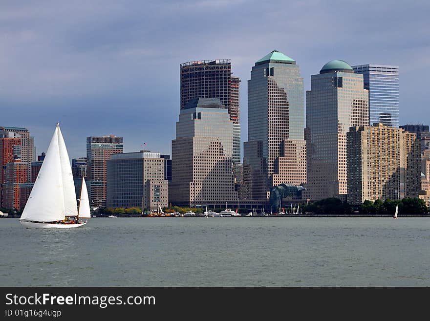 Sail boats sail past the southern tip of New York City. Sail boats sail past the southern tip of New York City