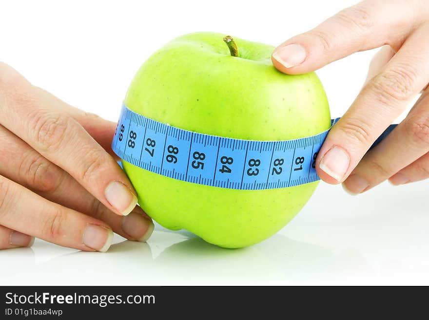 Woman's hands holding bright green apple and measuring tape isolated on a white background. Woman's hands holding bright green apple and measuring tape isolated on a white background