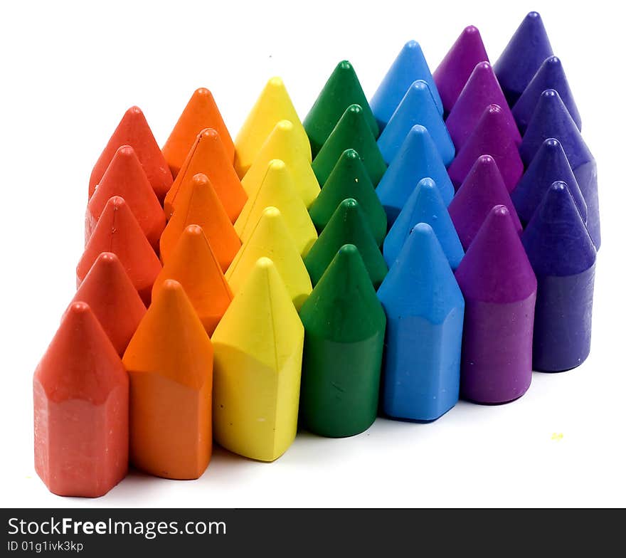 Rainbow stacked wax crayons on white background