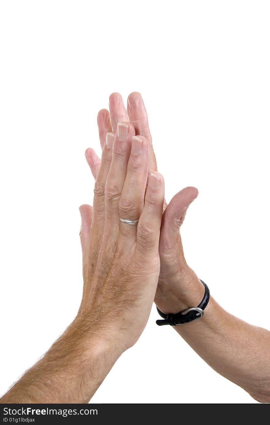 Male hand slapping female hand in 'high fives' gesture of congratulation. White background.