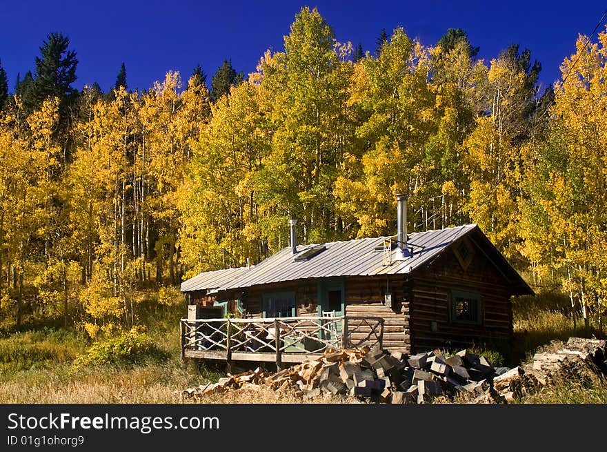 A country cabin in Colorado in Autumn with Aspen trees. A country cabin in Colorado in Autumn with Aspen trees