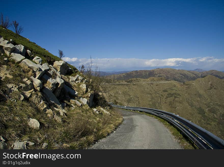 Sharp curve in a mountain road with mountains in background