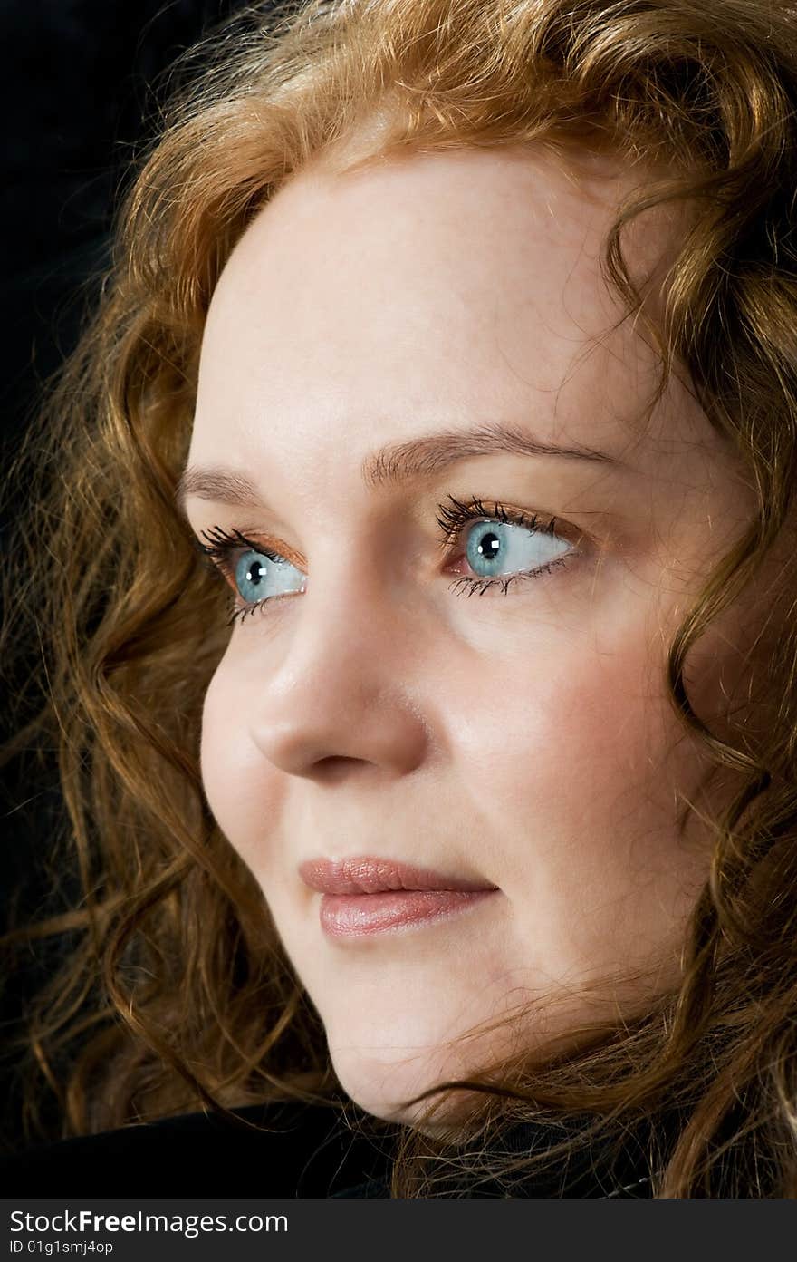 Portrait of a beautiful blue eyed woman on black background