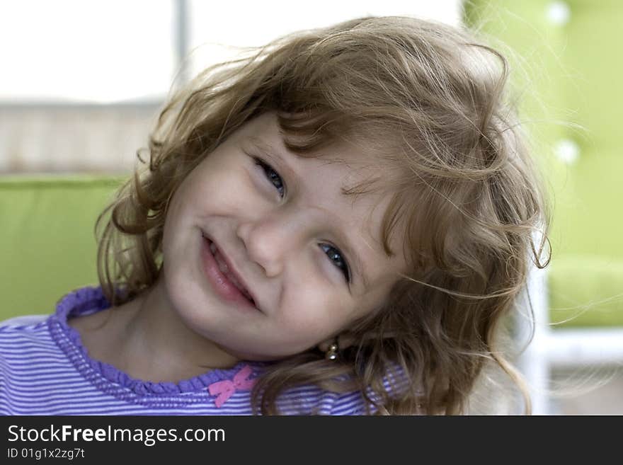 Little Girl Smiling at Camera with chairs in the background