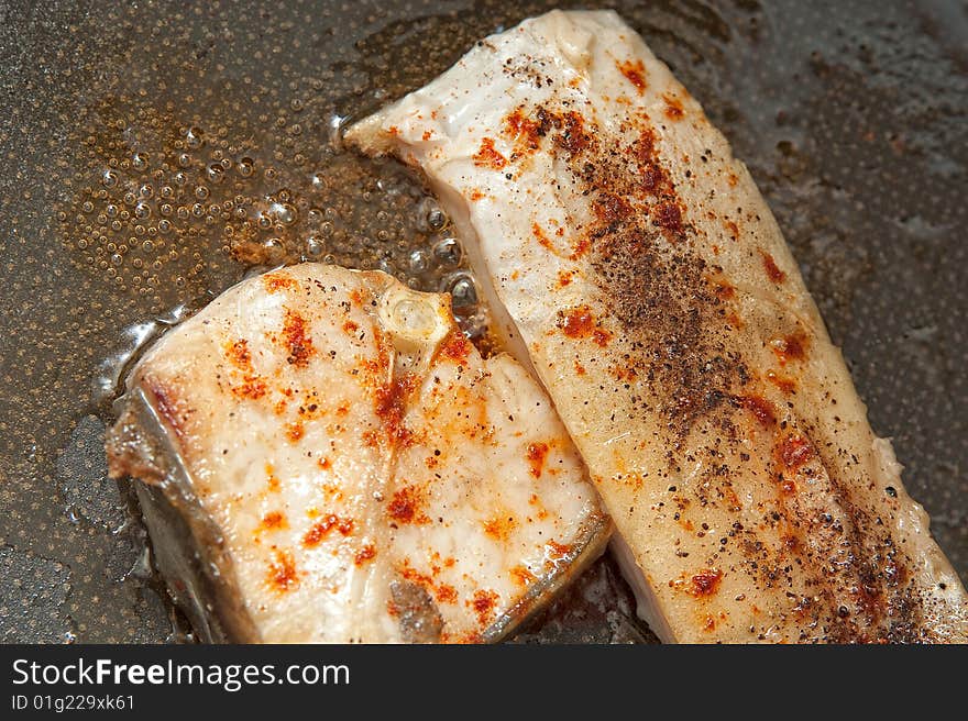 Fried fish with spices in the cooking pan