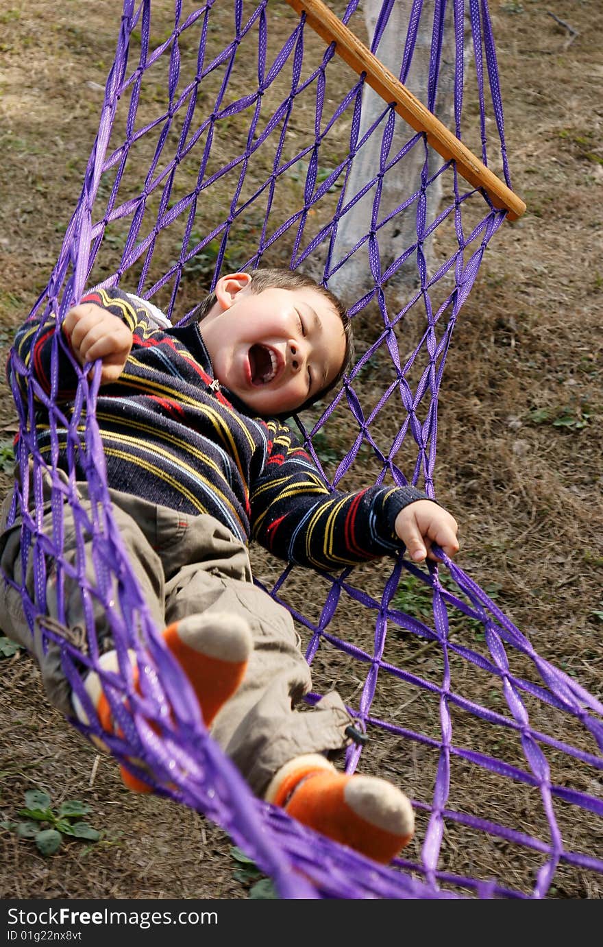 A picture of a little chinese boy laughing and having great fun in hammock. A picture of a little chinese boy laughing and having great fun in hammock