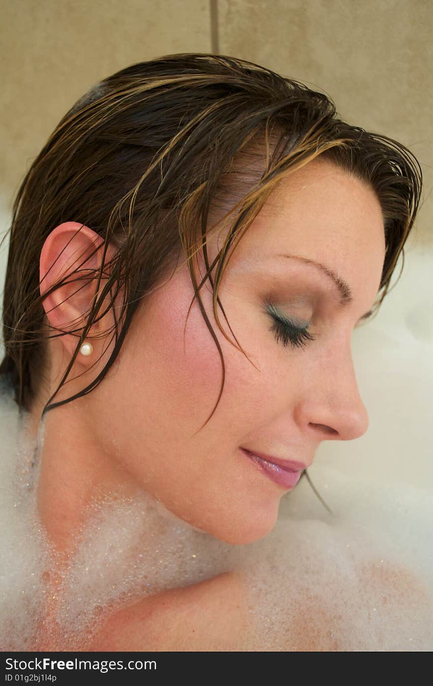 Beautiful brunette women, taking a relaxing bubble bath, wearing pearl earrings. Beautiful brunette women, taking a relaxing bubble bath, wearing pearl earrings.