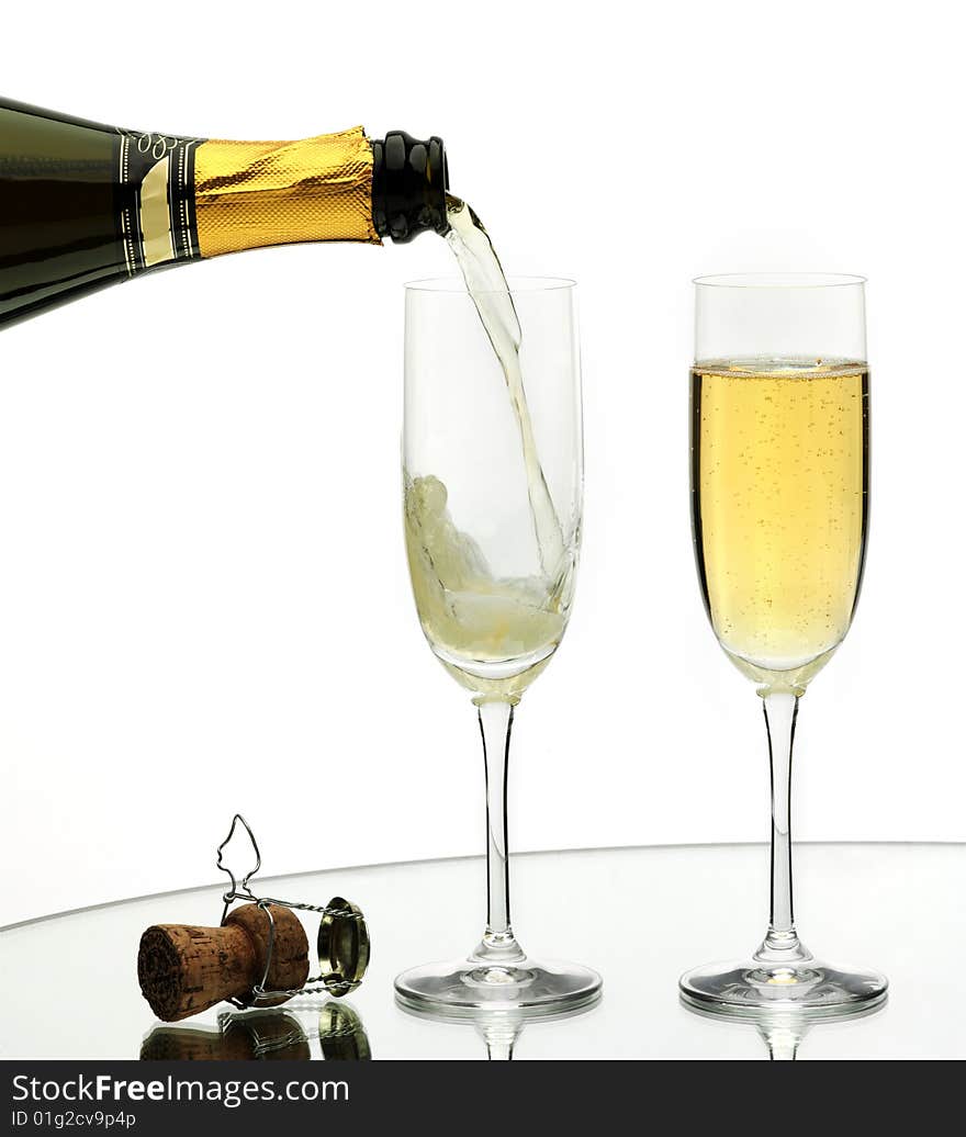 Champagne being poured into a flute, isolated on a white background. Champagne being poured into a flute, isolated on a white background.