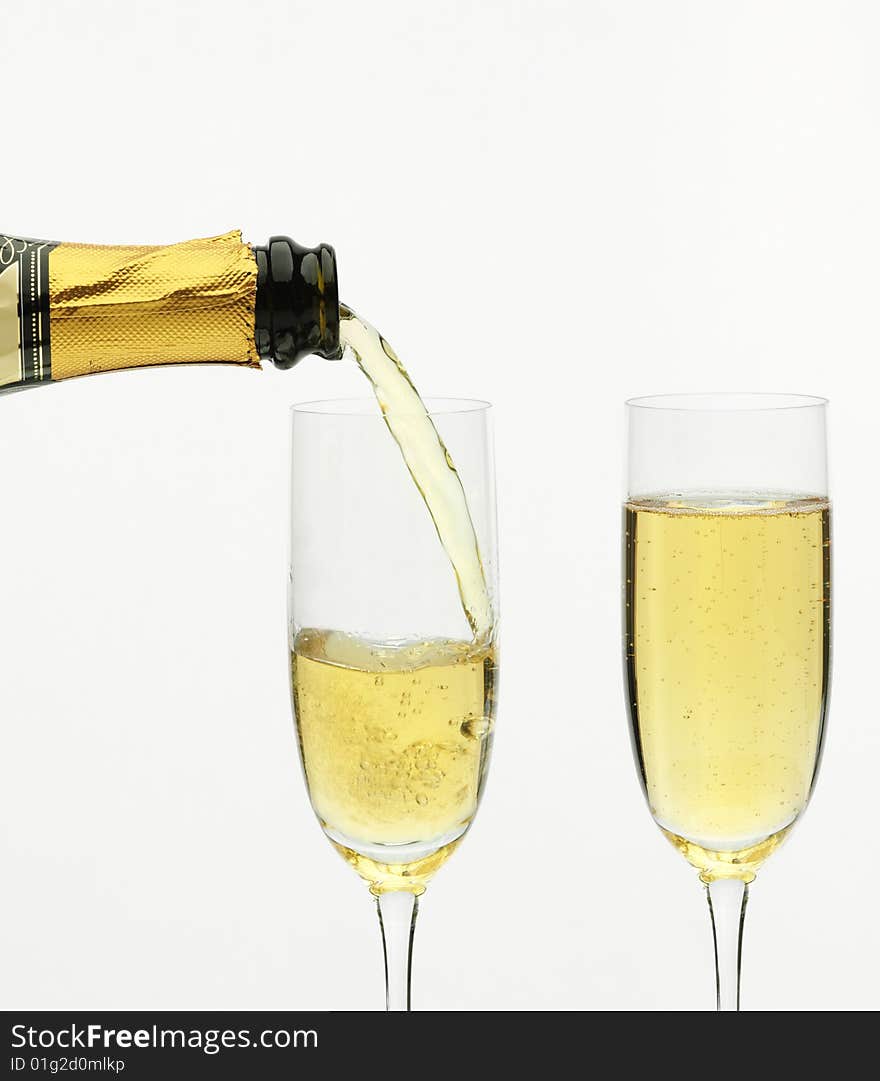 Champagne being poured into a flute, isolated on a white background. Champagne being poured into a flute, isolated on a white background.