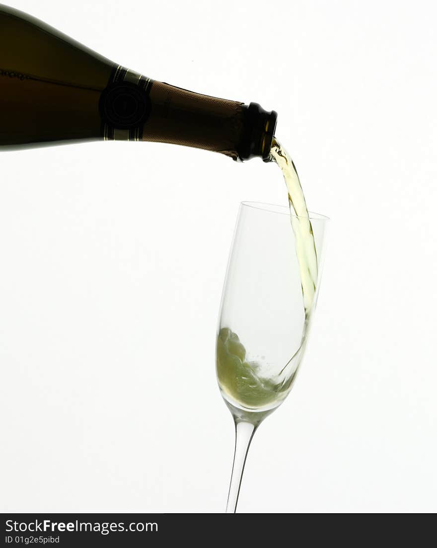 Champagne being poured into a flute, isolated on a white background.