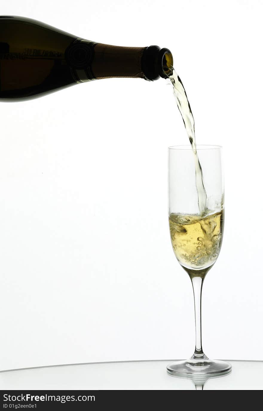 Champagne being poured into a flute, isolated on a white background.