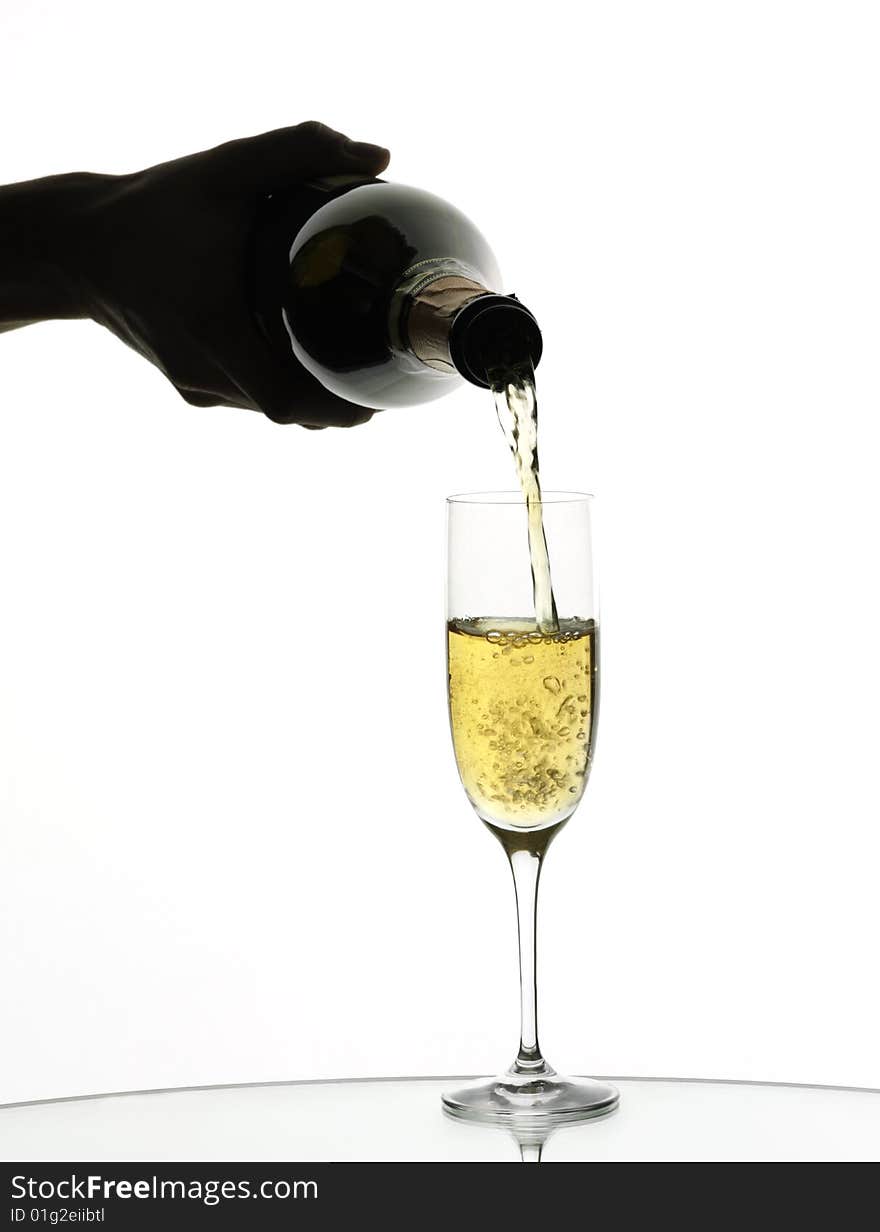 Champagne being poured into a flute, isolated on a white background.