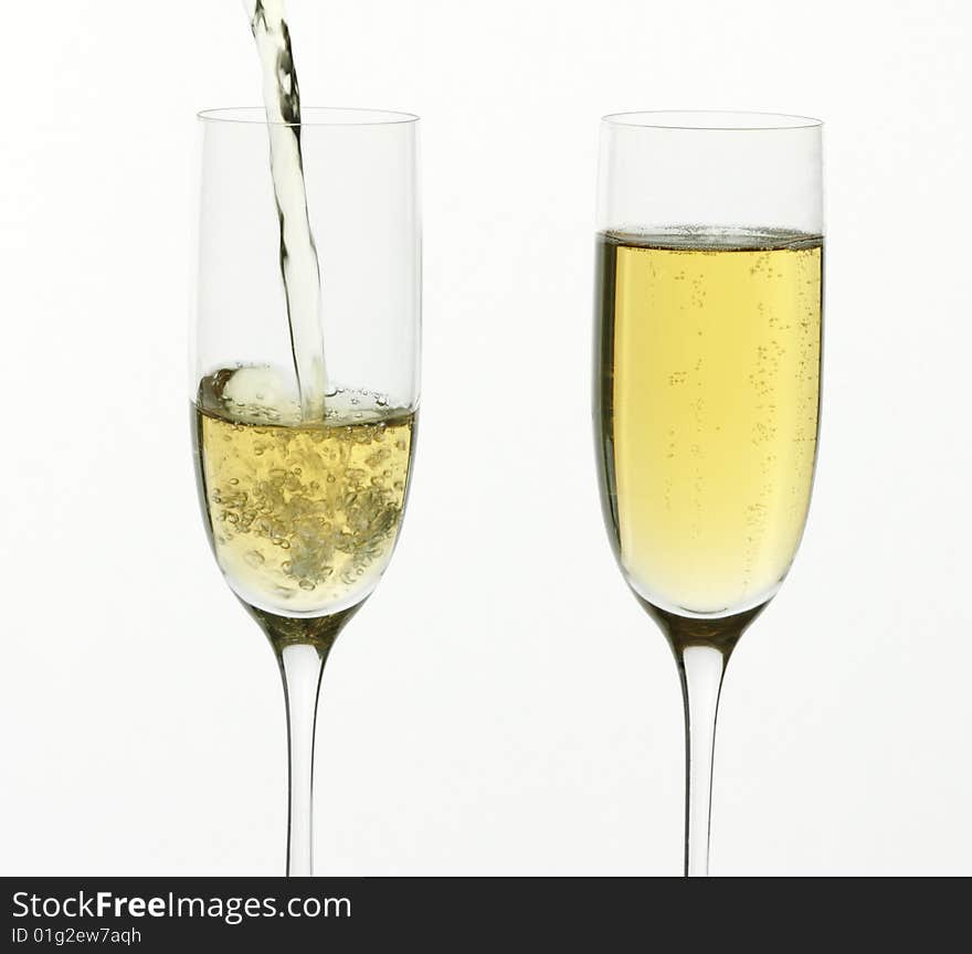 Champagne being poured into a flute, isolated on a white background. Champagne being poured into a flute, isolated on a white background.