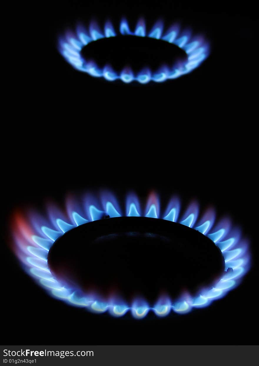 Blue flame of gas over black background