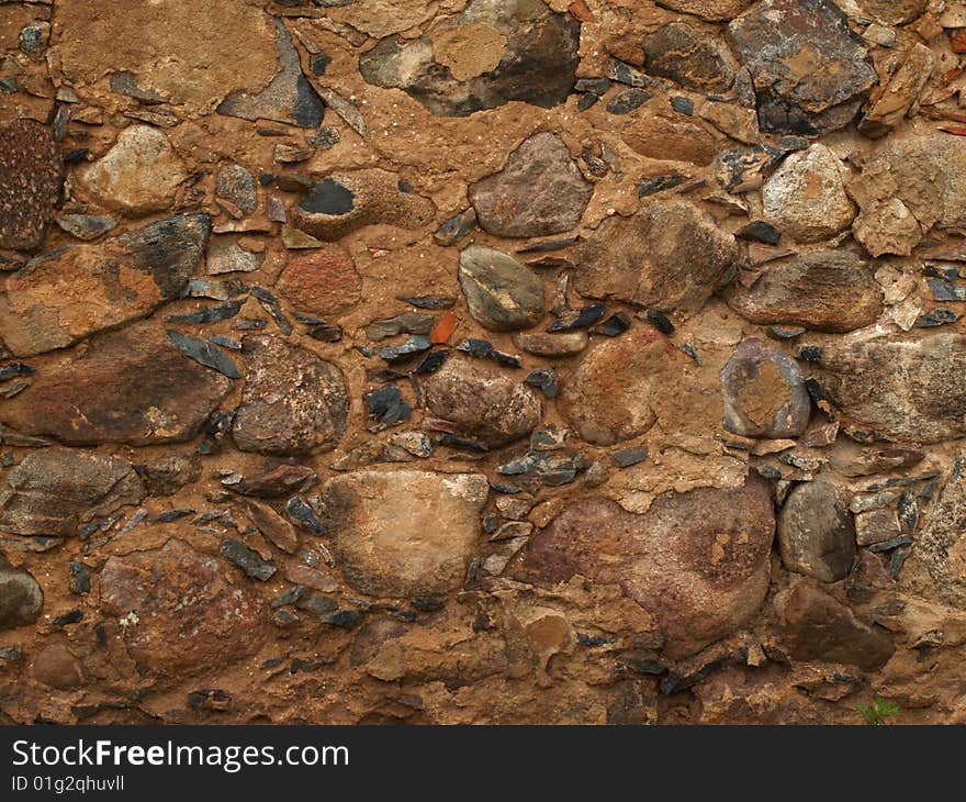 Wet stony wall with different size rocks