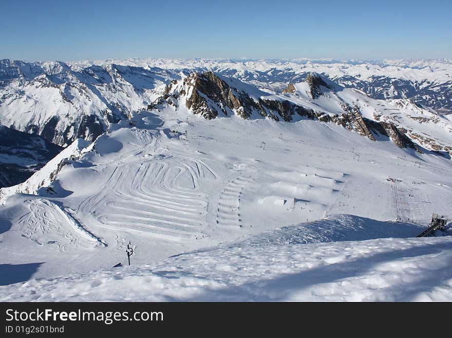 Austria. Mountains. The Alpes.Snow. The sun. Mountain tops.The bright dark blue sky.Hillside for skiing.