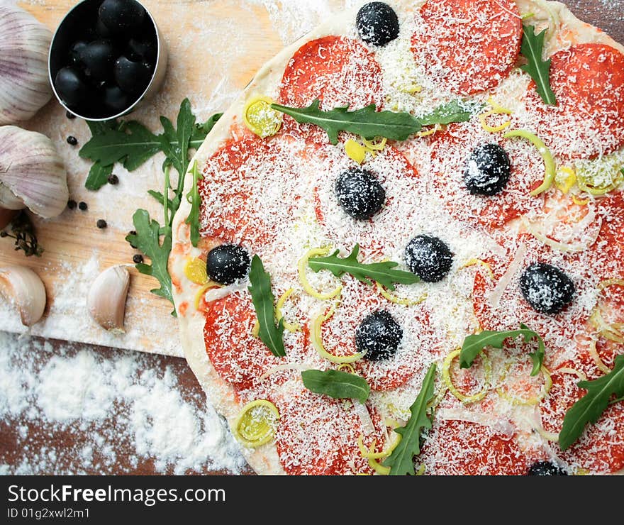 Pizza, olives, garlic, rukola, herbs on the table. Pizza, olives, garlic, rukola, herbs on the table