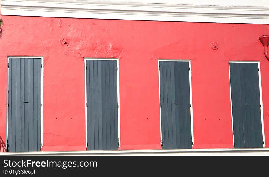 Red building with green shutters, in horizontal orientation