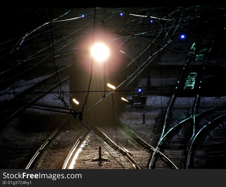 The locomotive on the rail crossing at night. The locomotive on the rail crossing at night