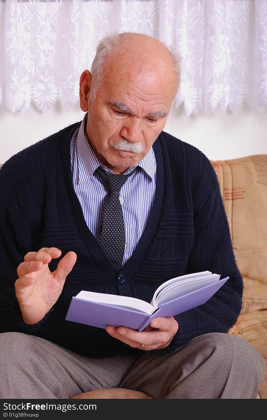 A grandfather reading book in the living room. A grandfather reading book in the living room