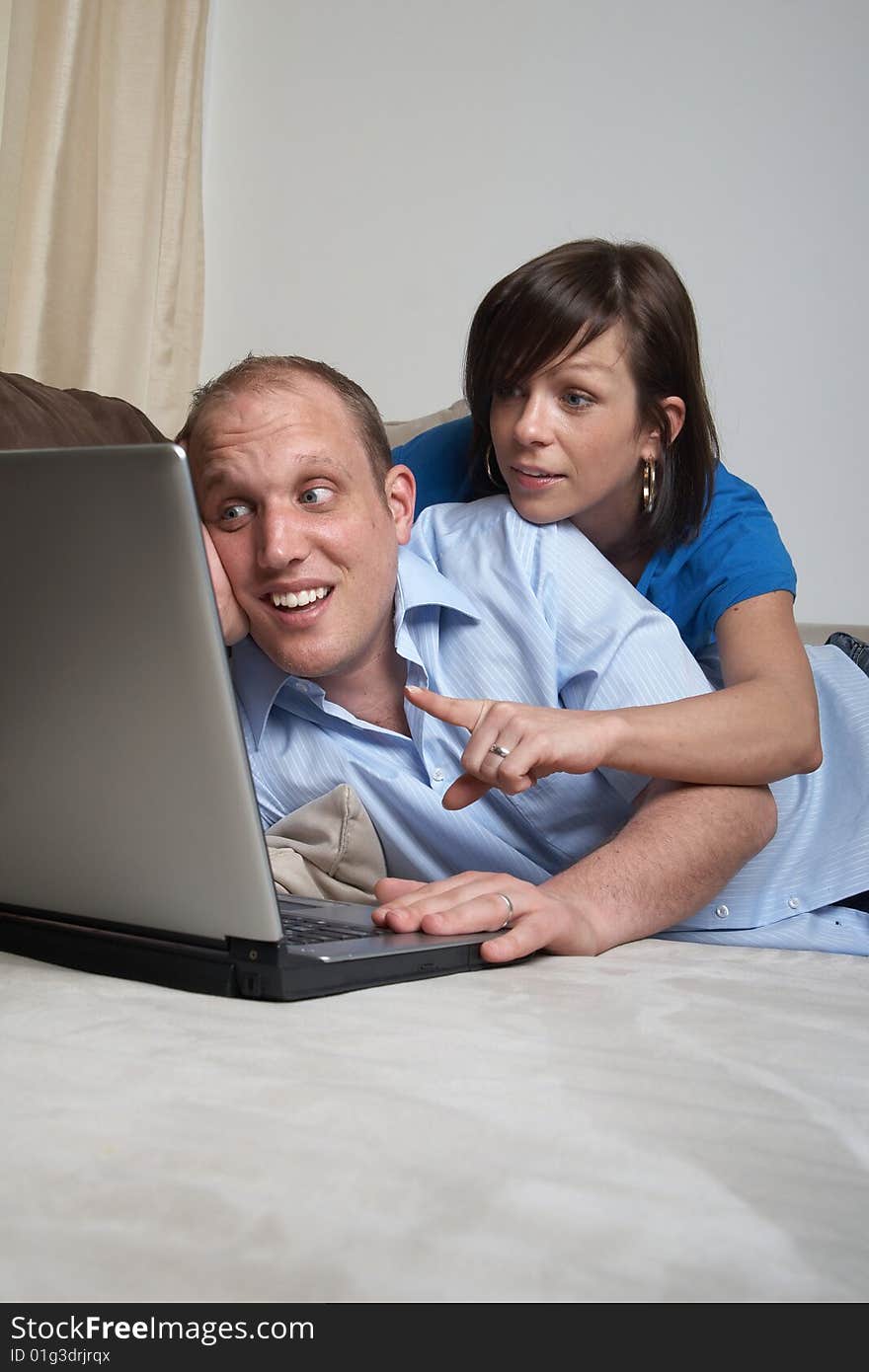 Young couple on the couch at home looking at the laptop!. Young couple on the couch at home looking at the laptop!