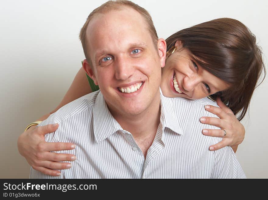 A young couple in love. The woman hugs the man from behind. A young couple in love. The woman hugs the man from behind.