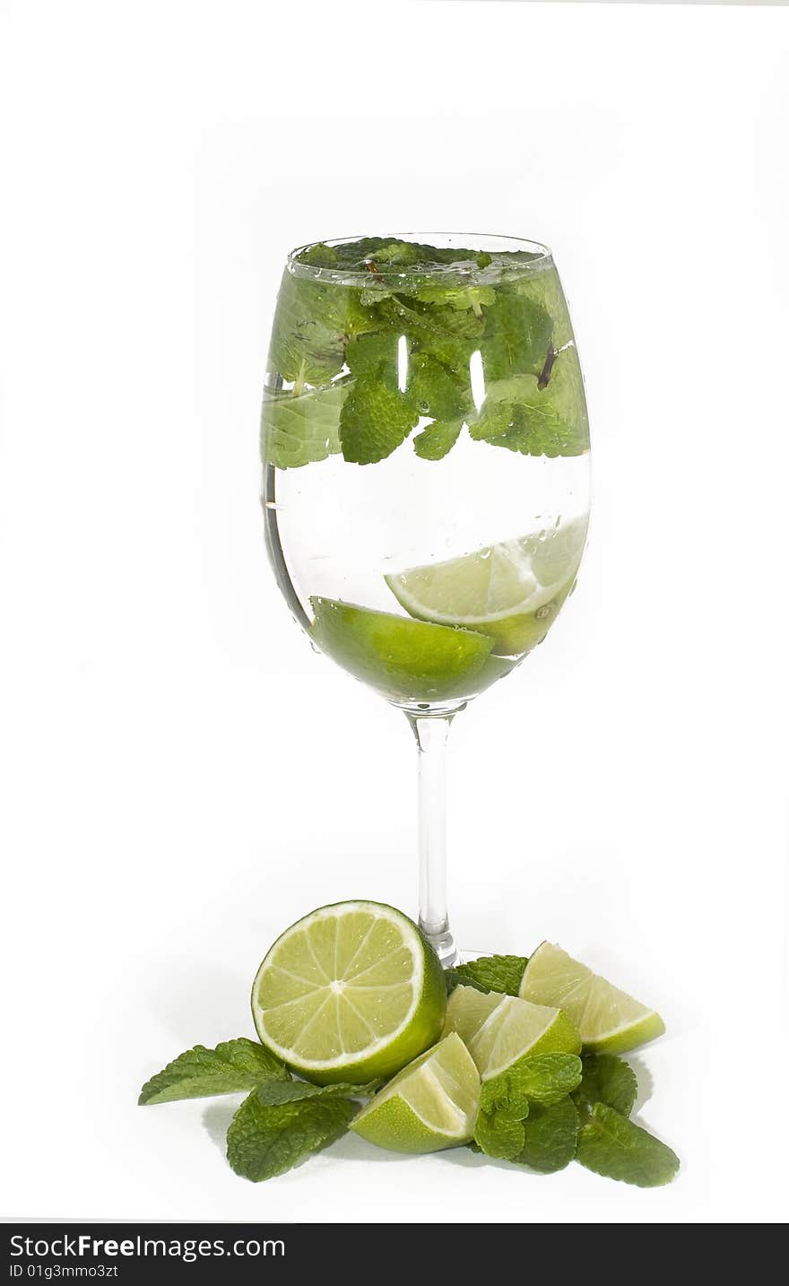 Glass with cocktail, limes with mint leaves, isolated on white background