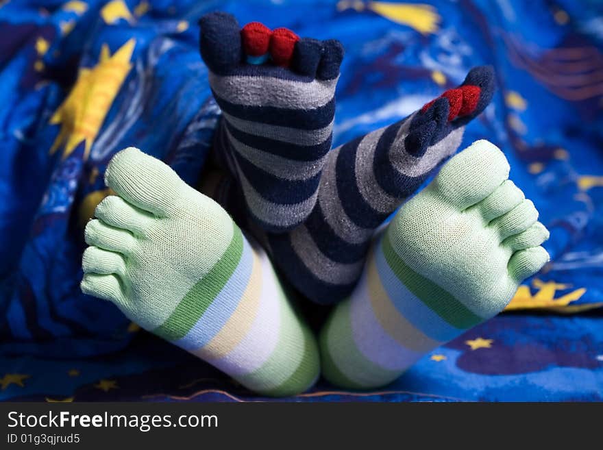 Stock photo: an image of two pairs of funny feet in striped socks