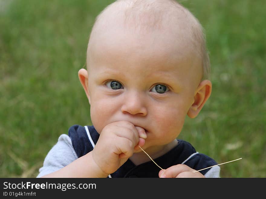 The little boy works as photomodel on a meadow. The little boy works as photomodel on a meadow