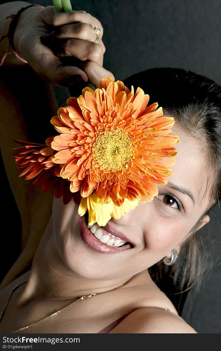 Girl model holding a orange flower. Girl model holding a orange flower.