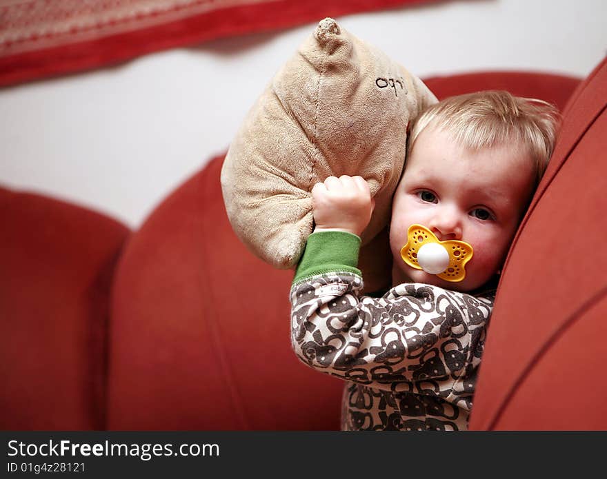 Small baby girl makes fun on sofa