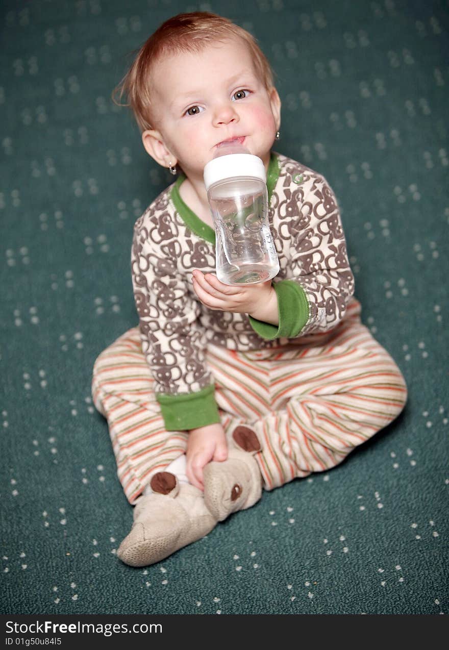 Small baby girl drink watter from a bottle