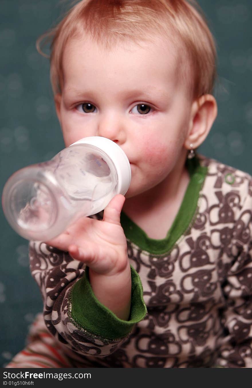 Small baby girl drink water from a bottle