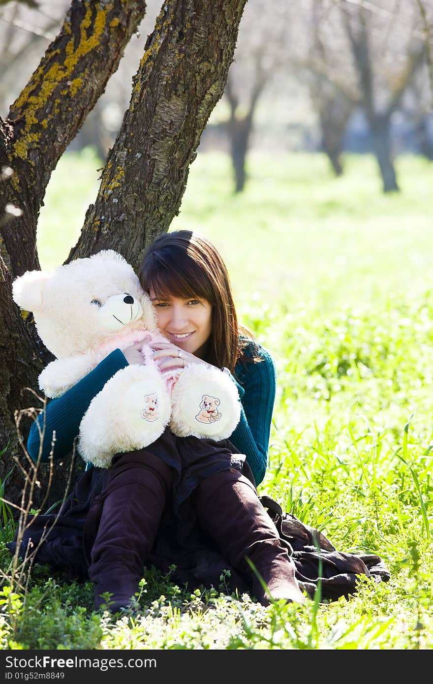 Young smiling woman embracing a teddy bear. Young smiling woman embracing a teddy bear