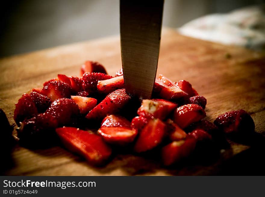 A few strawberries cutted in half on a kitchen table. A few strawberries cutted in half on a kitchen table